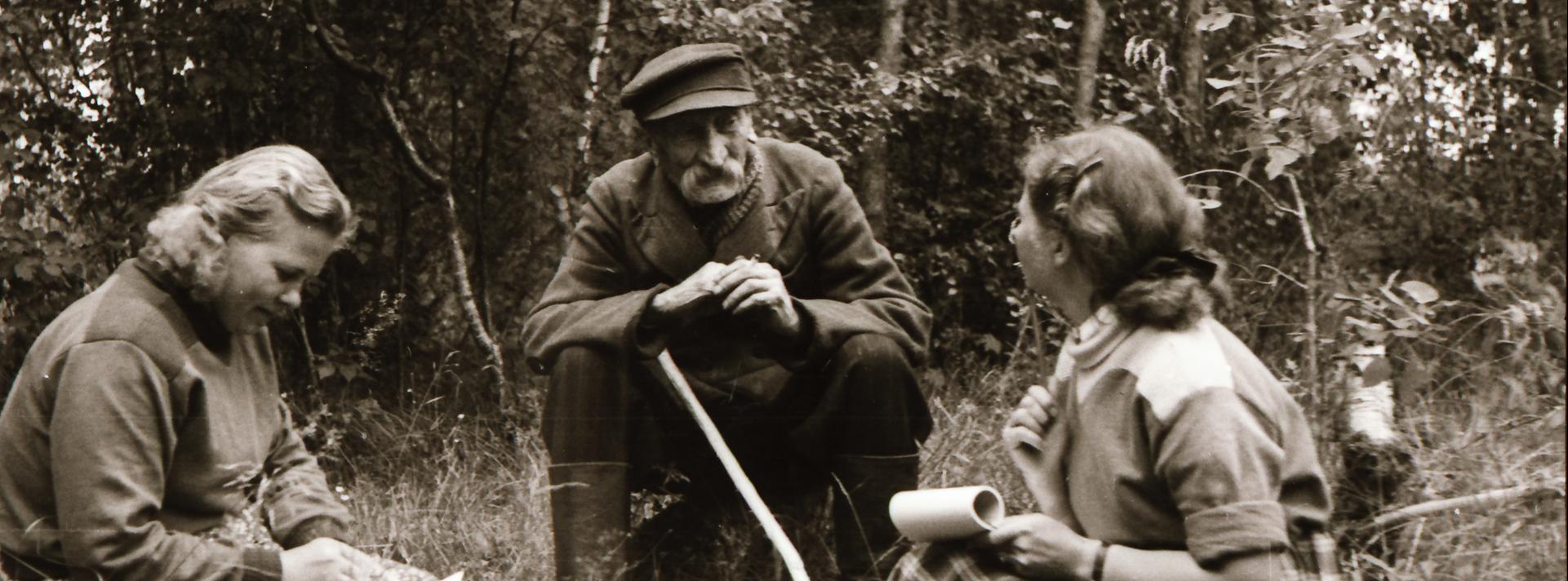 Fotol Iisaku rahvaluule ekspeditsioon 1955. aastal. Eduard Reiska jutustab meile mitmesuguseid jutte, endisaegseid kombeid ja uskumusi. Foto: Richard Viidalepp (KKI, Foto 87)