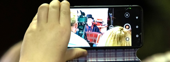 Fotol on käsi mobiiliga, mis pildistab.