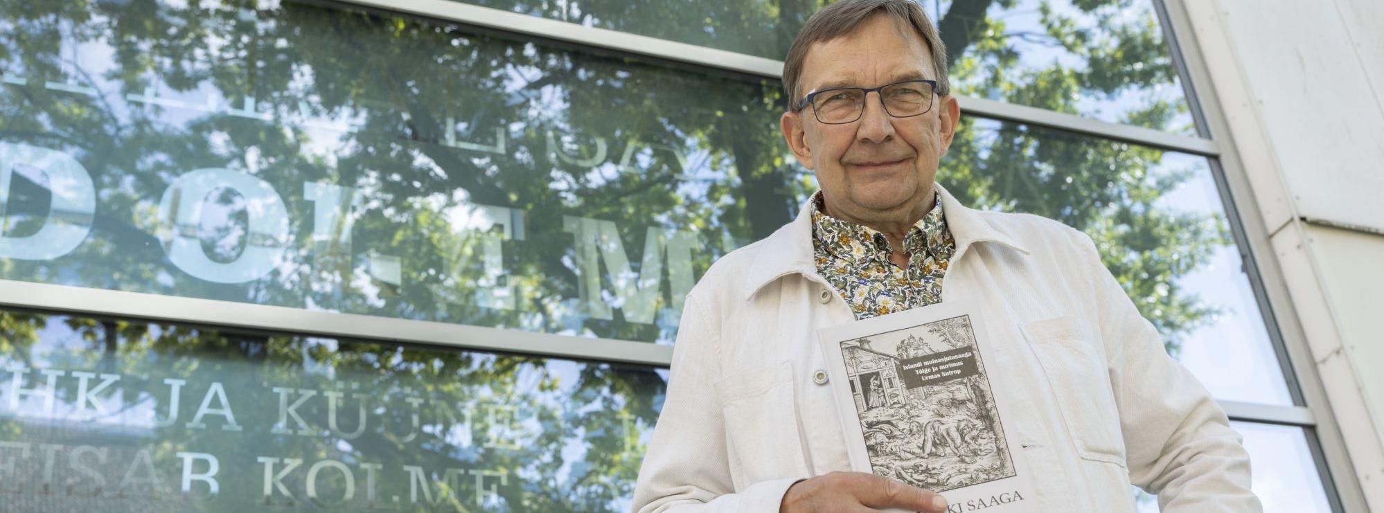 Urmas Sutrop Ali flekii saagaga poseerimas kirjandusmuuseumi trepil
